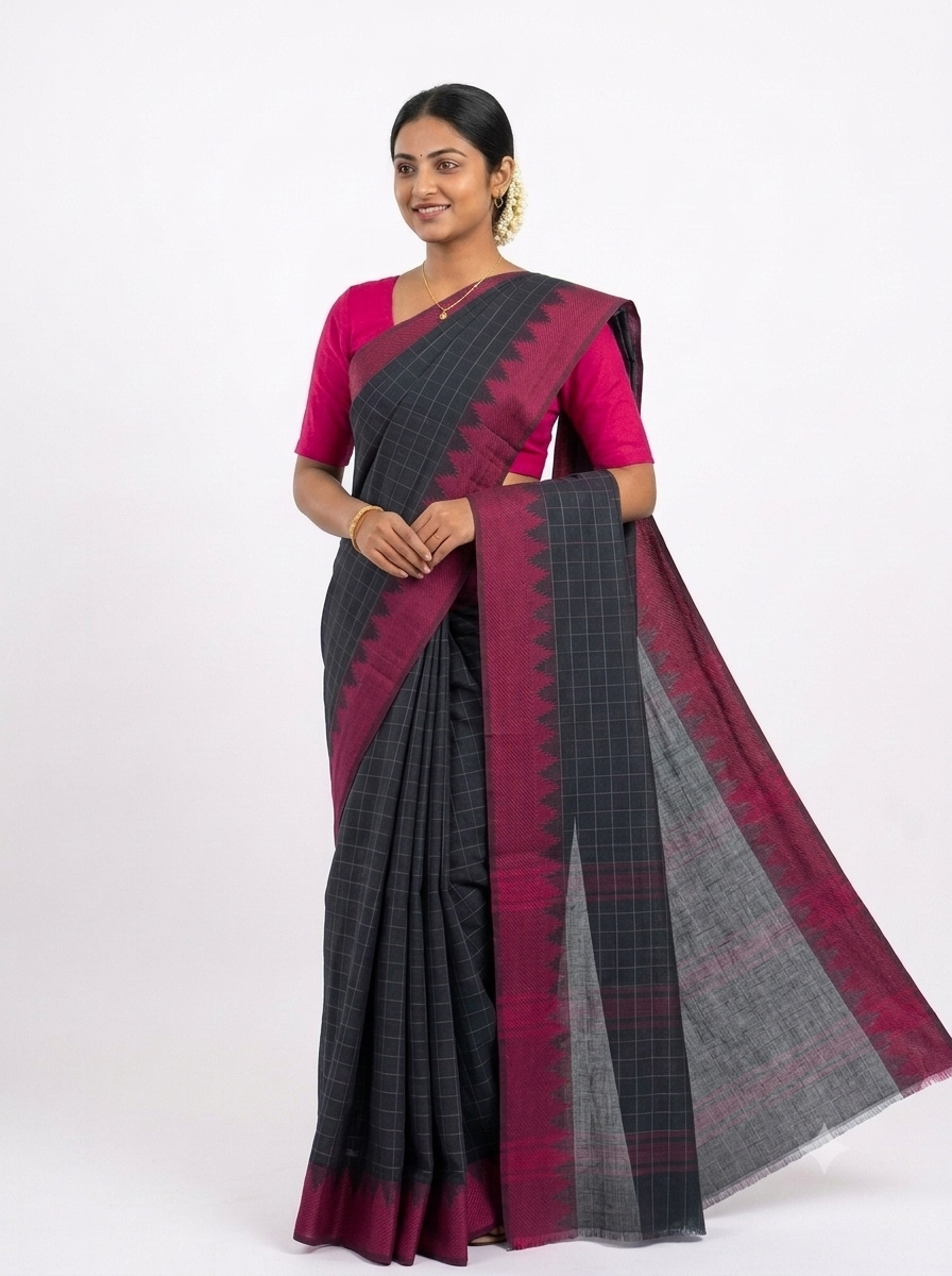 A woman modeling a dark gray and magenta saree with a matching magenta blouse, set against a plain white studio background.