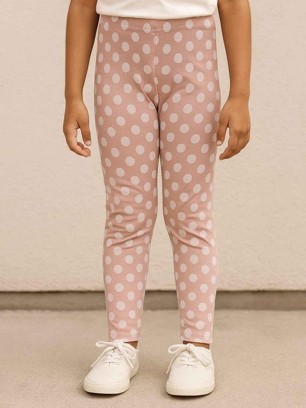 Person wearing pink polka dot leggings with a plain background
