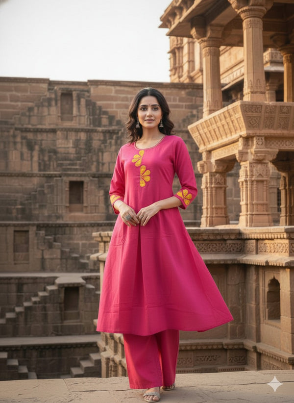 Woman in a pink traditional outfit standing in front of ancient architecture