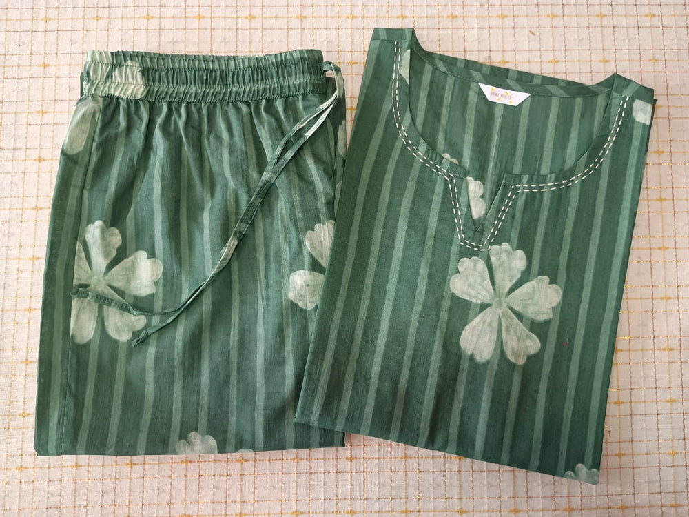 Green striped shirt and shorts with white four-leaf clover patterns on a grid background