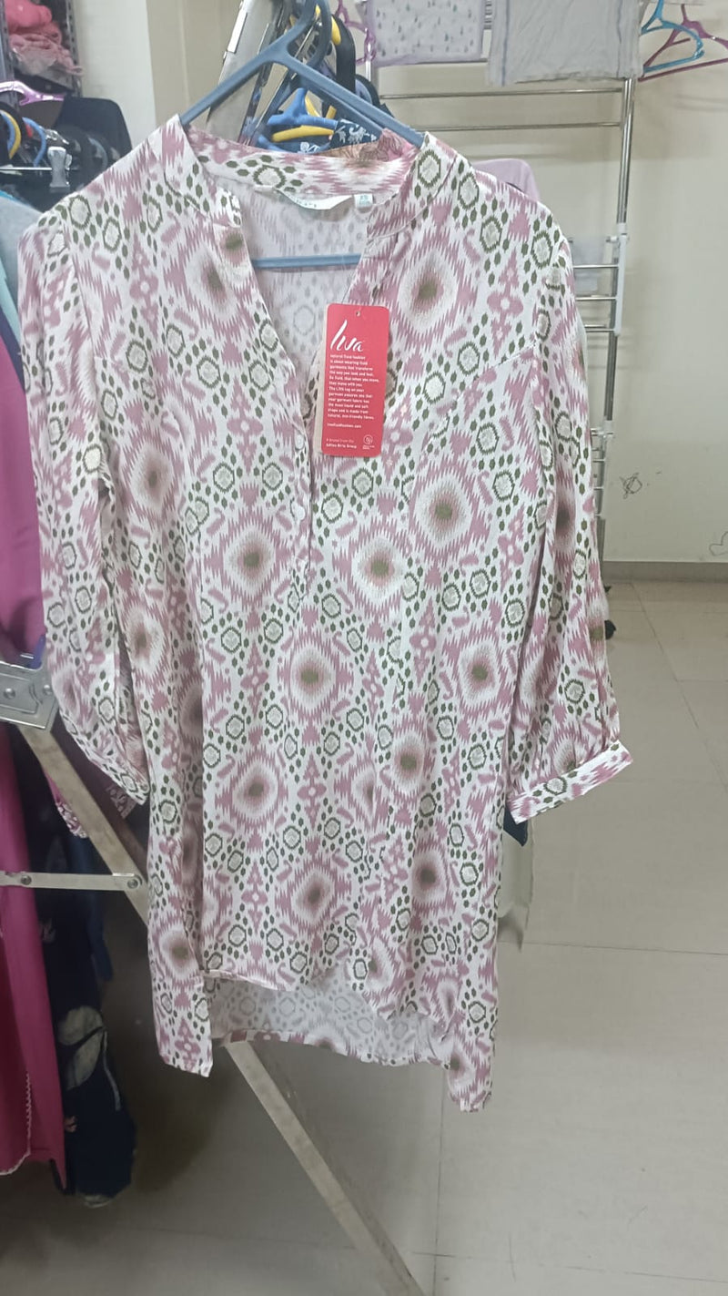 Floral-patterned shirt on a hanger with a visible tag in a store setting.